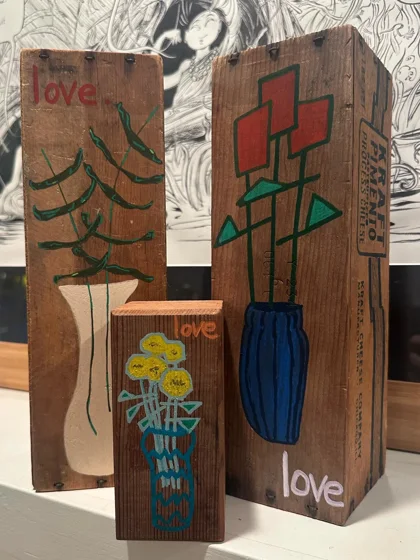 Love Boxquets. Upright wooden pieces painted with stylized flowers in vases and the word love.